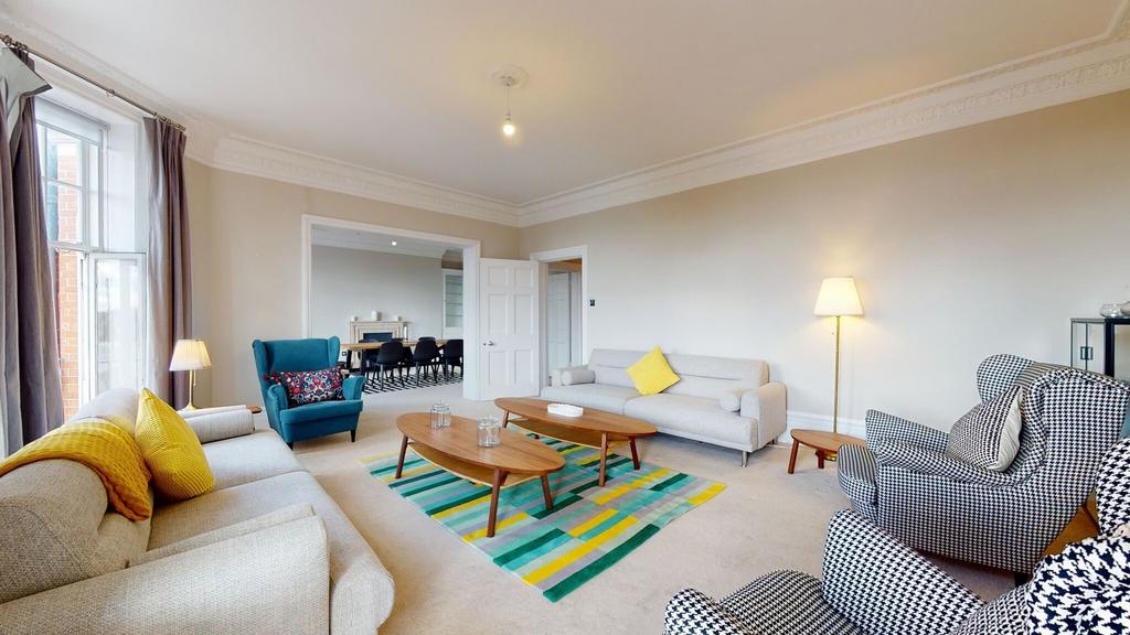 A spacious and stylish living room featuring la...