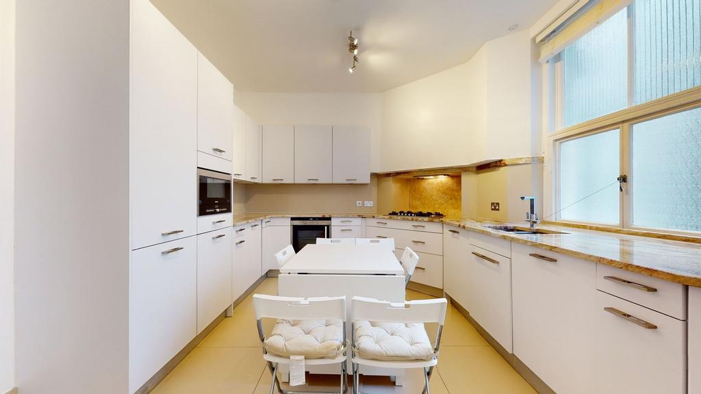 Bright and modern kitchen featuring ample white...