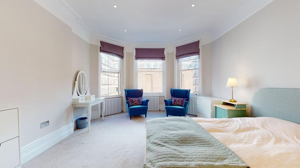 Bright and spacious master bedroom featuring a ...