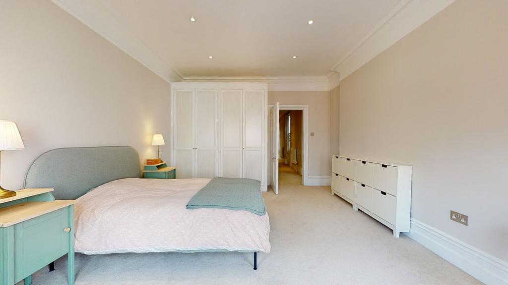 A spacious and well-lit master bedroom featurin...