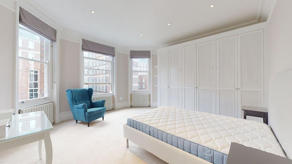 Bright and spacious master bedroom featuring la...