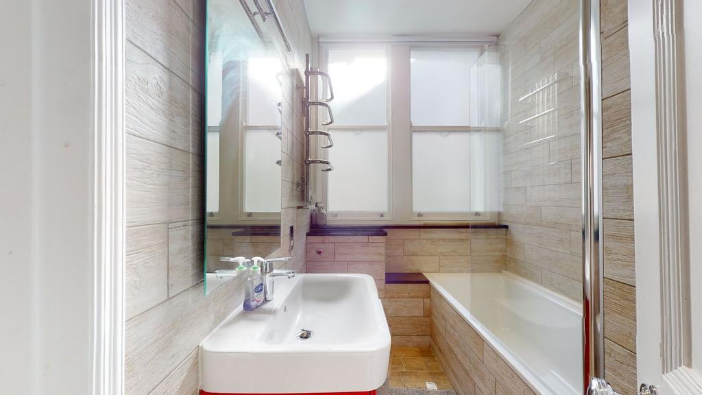 A modern and bright bathroom suite featuring a ...