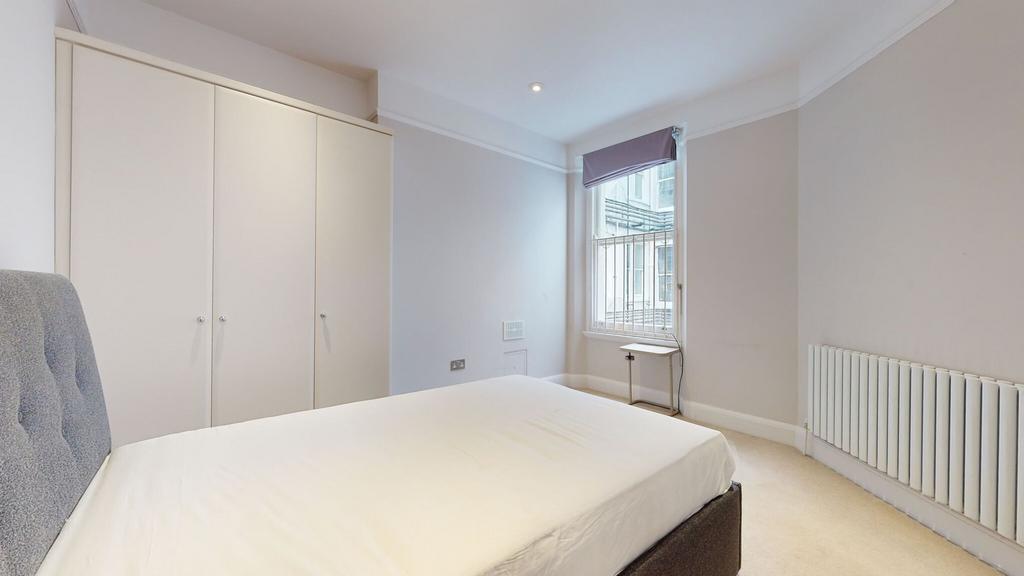 A neat and tidy double bedroom featuring a comf...