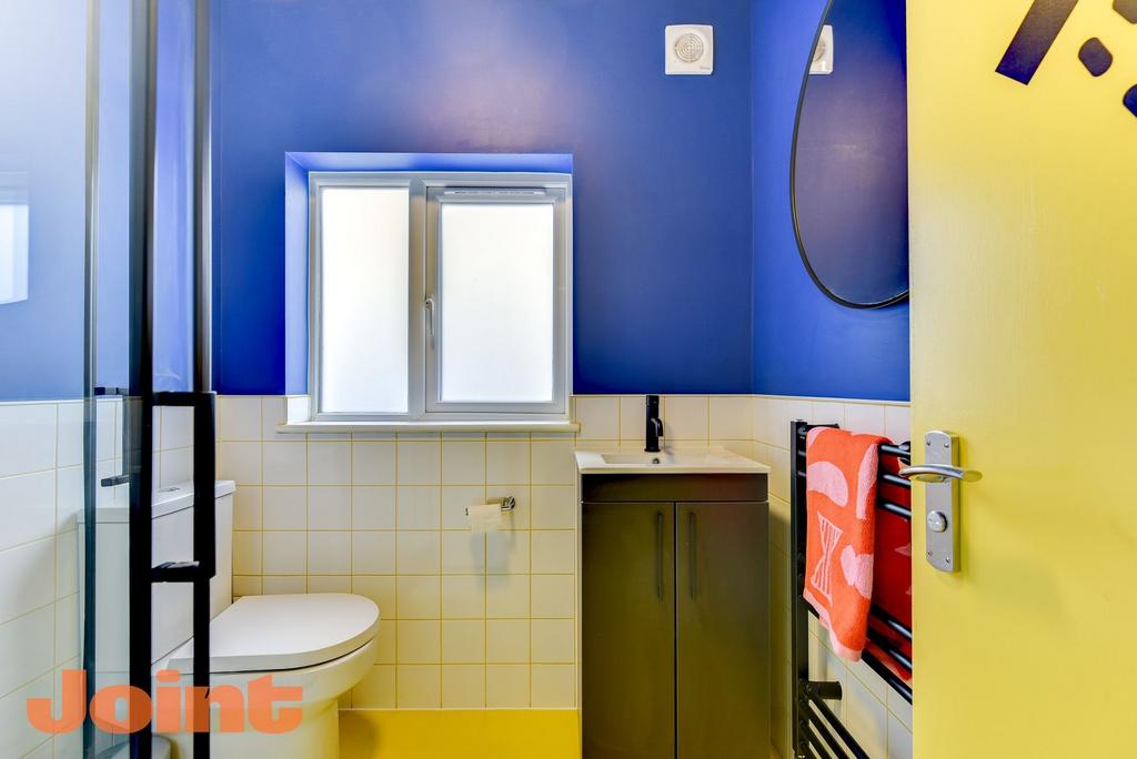 Bright, modern bathroom with bold blue walls, f...