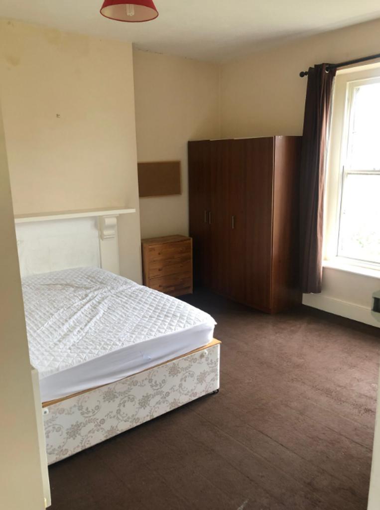 A tidy double bedroom featuring a bed and wardr...