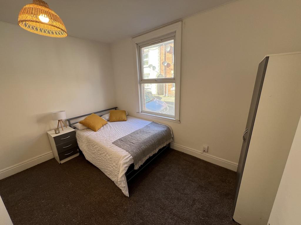A well-lit, cozy double bedroom featuring a com...