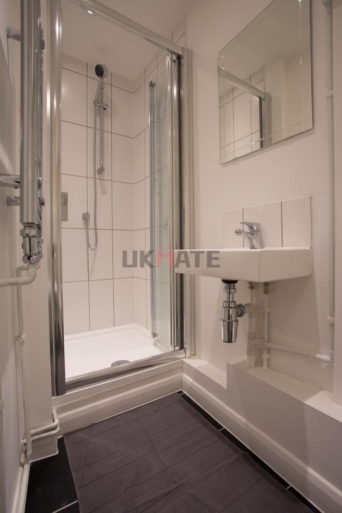 A clean and compact bathroom featuring a shower...