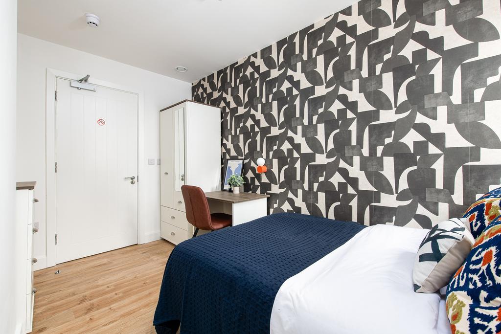 A stylish double bedroom featuring a cozy bed w...