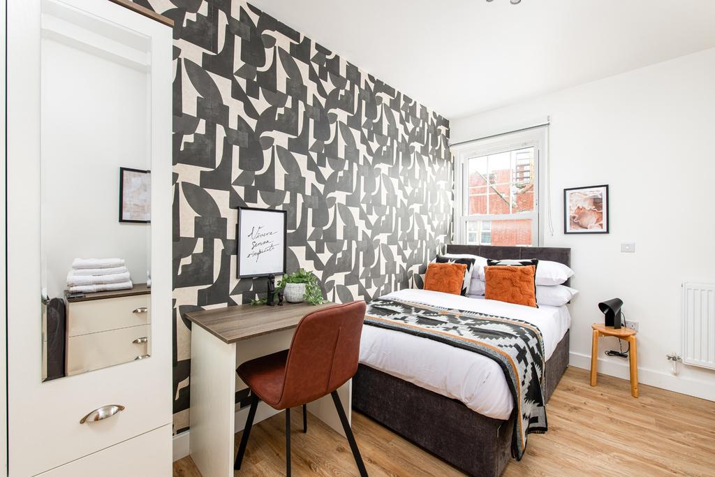 A spacious and well-lit bedroom featuring a sty...
