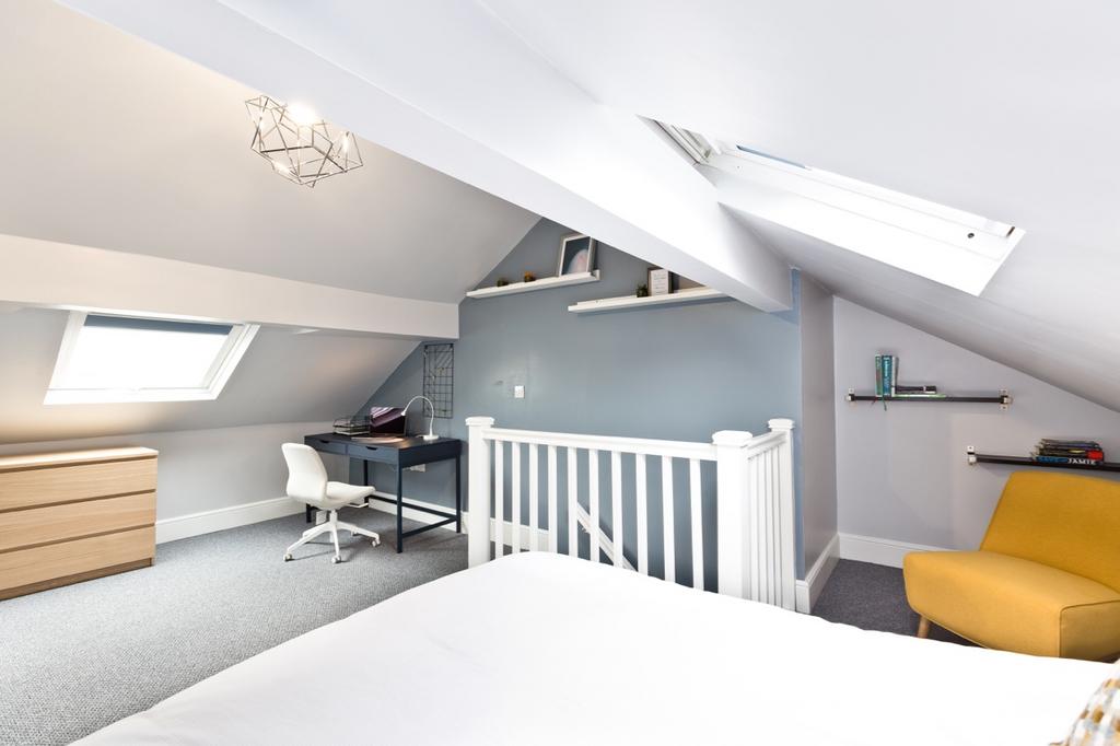 Bright and airy bedroom with skylights and neut...