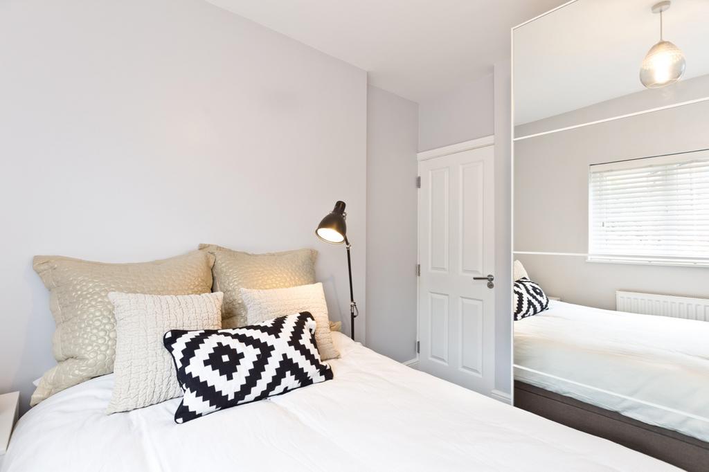 A bright and stylish bedroom featuring a neatly...