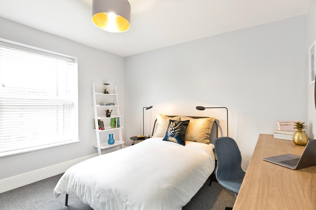 Bright and welcoming double bedroom featuring a...