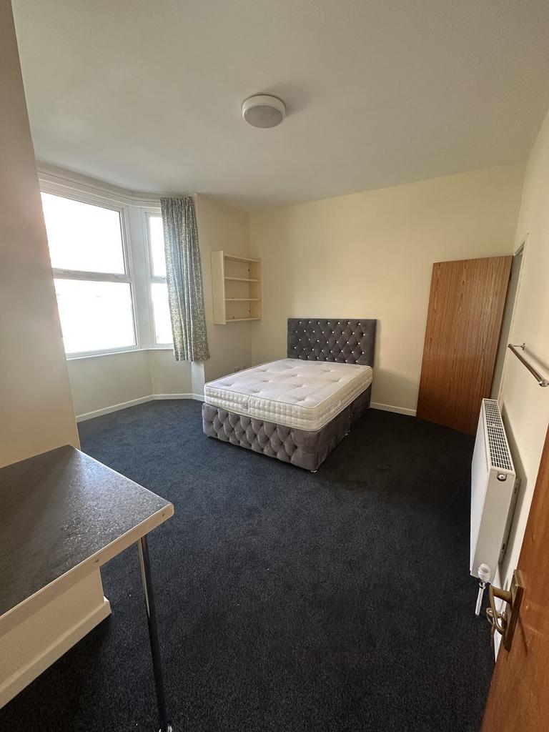 A bright and inviting double bedroom with a lar...