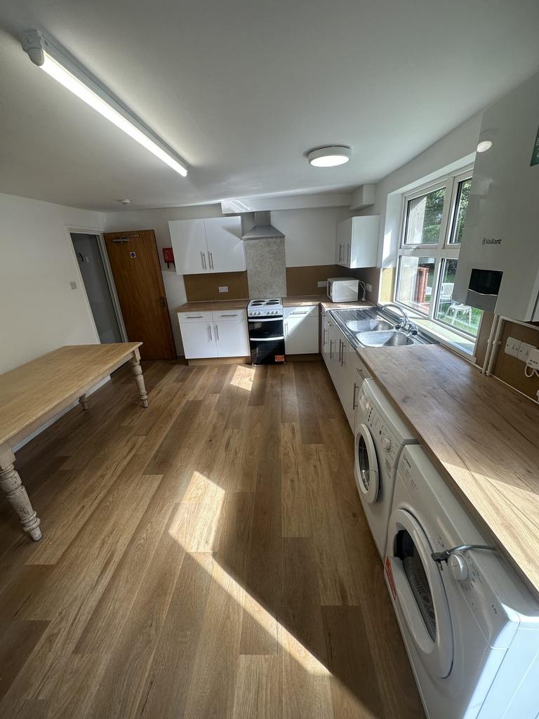 Bright, modern kitchen with long wooden worktop...