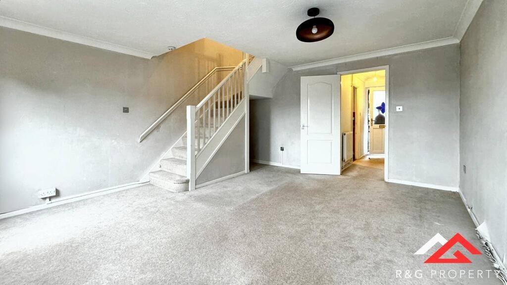 A spacious, clean living room featuring neutral...