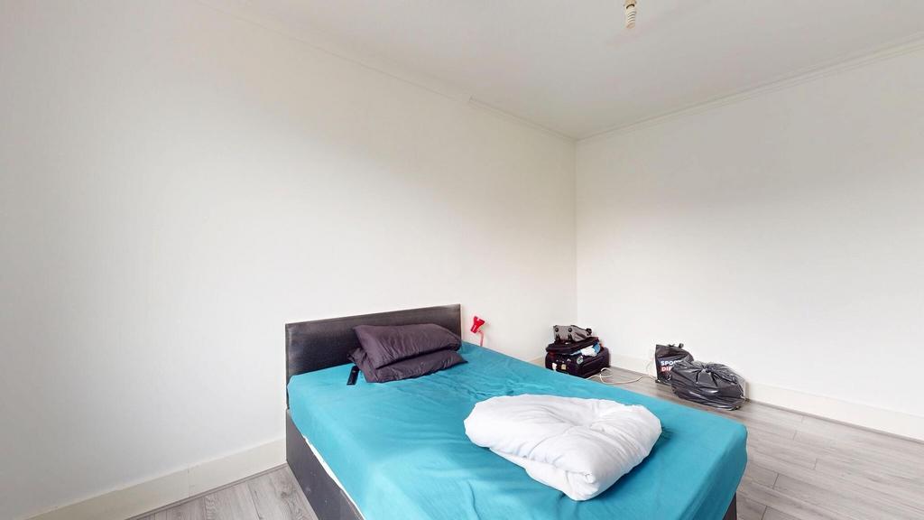 A well-lit double bedroom featuring a large bed...
