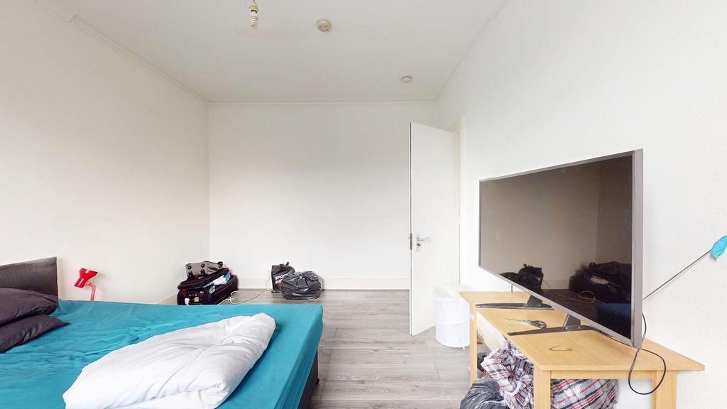 A cozy living room featuring a large flat-scree...