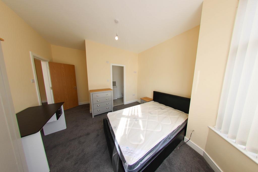 A spacious and well-lit master bedroom featurin...