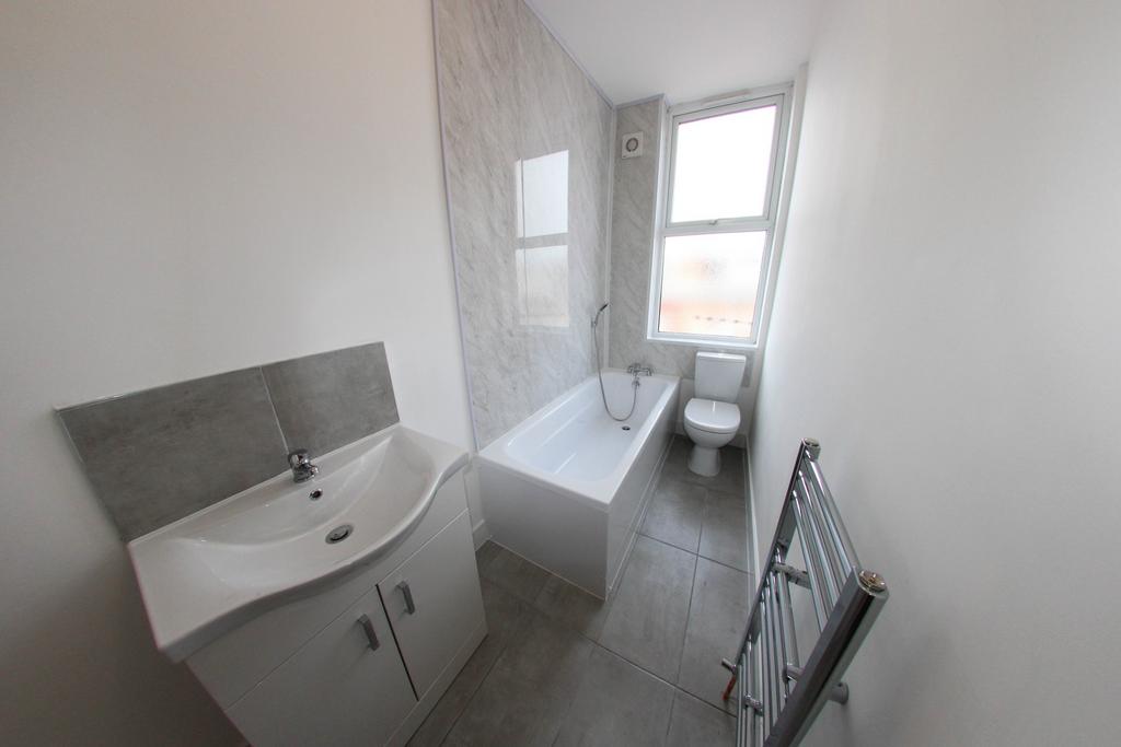 A clean and bright bathroom with a sink, bathtu...