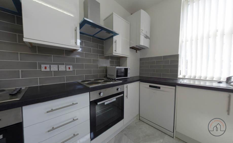 Bright modern kitchen with white cabinetry, int...