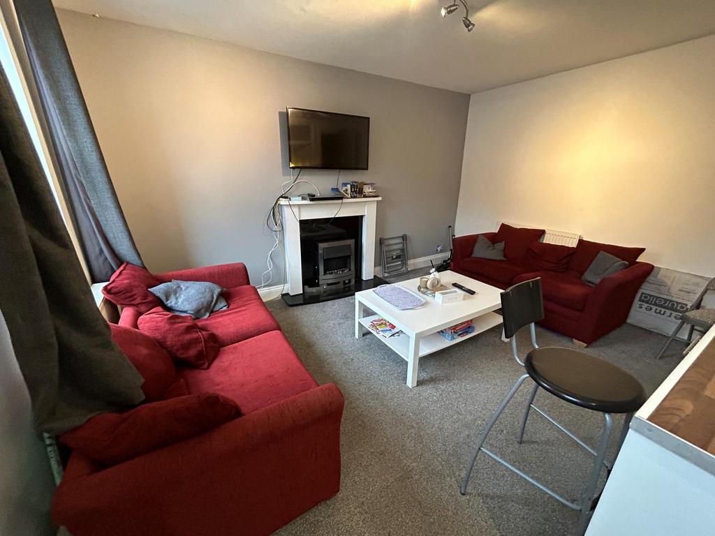 A spacious and well-lit living room featuring c...