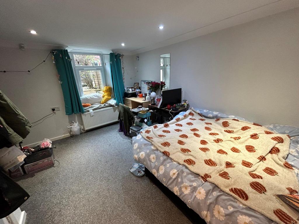 A cozy bedroom featuring a single bed and a win...