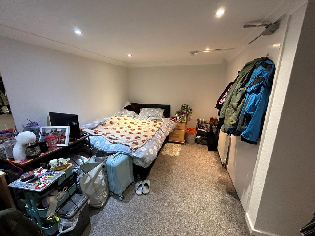 A cozy bedroom featuring a double bed, a desk a...