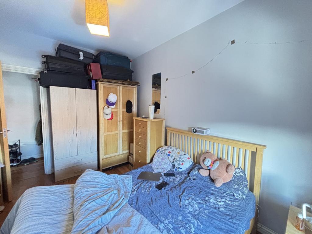 A cozy bedroom featuring a bed with plush toys,...