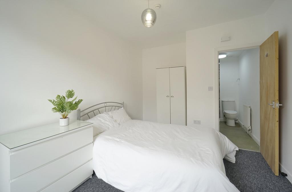 A bright and inviting master bedroom featuring ...