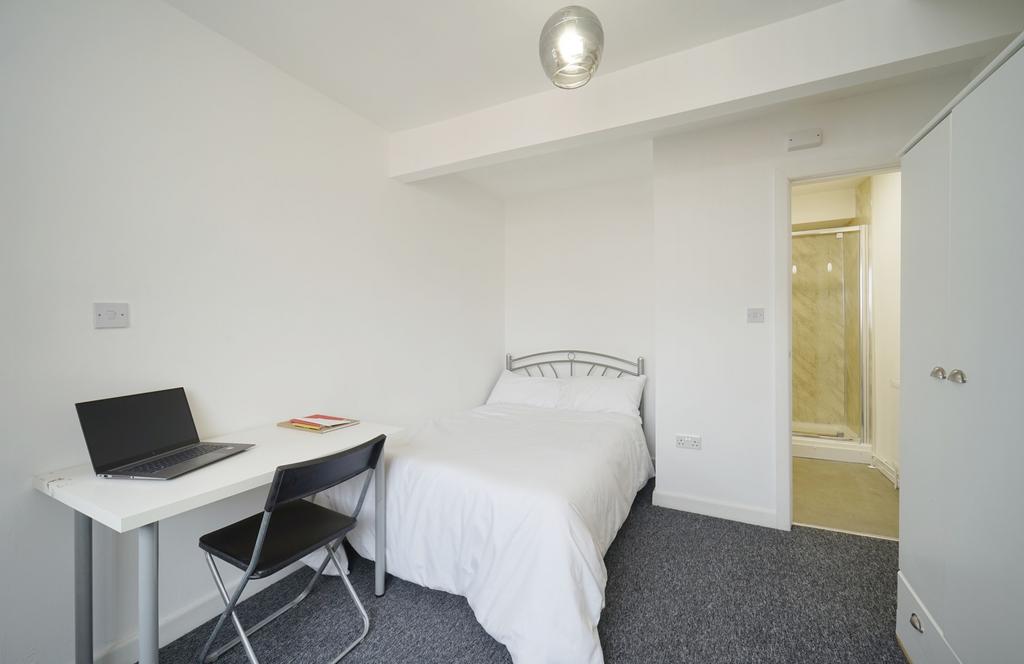 A bright and minimalist single bedroom featurin...
