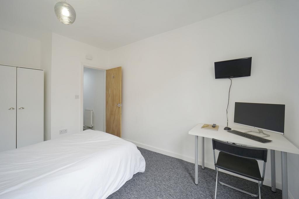 A bright and tidy bedroom featuring a comfortab...