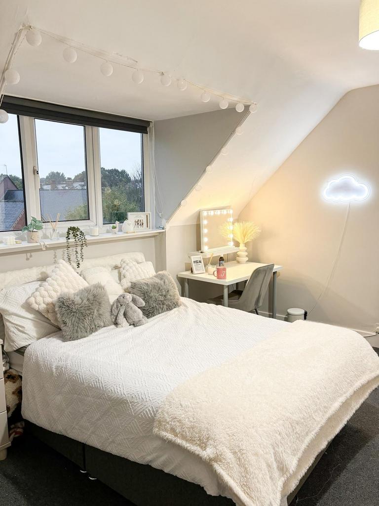 A spacious and well-lit master bedroom featurin...