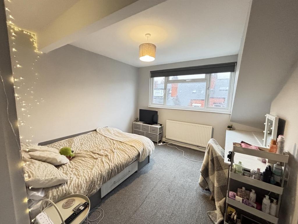 A bright and clean single bedroom featuring a c...