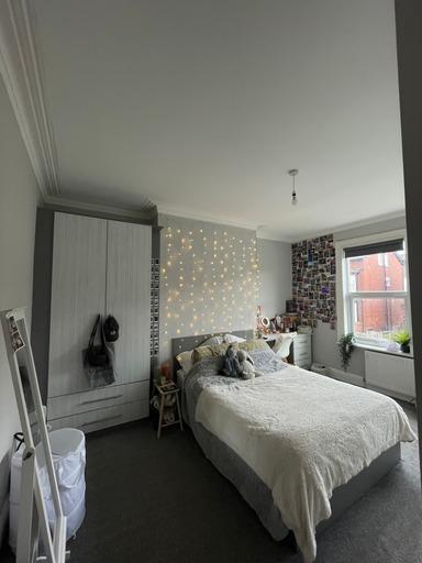 A bright and cozy bedroom featuring a comfortab...