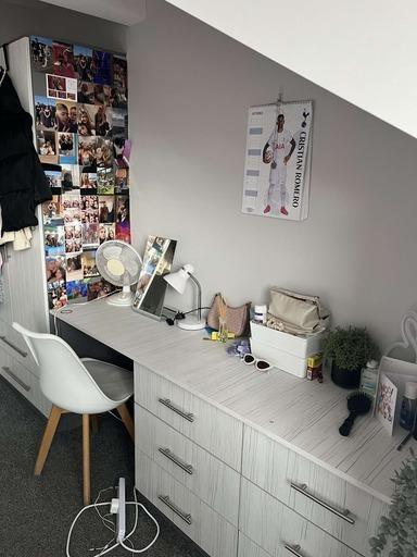 A tidy and well-organized bedroom with good nat...