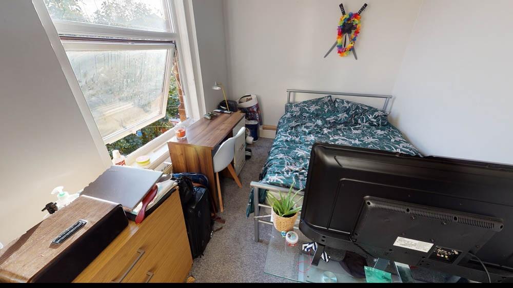 A cozy student bedroom featuring a single bed, ...