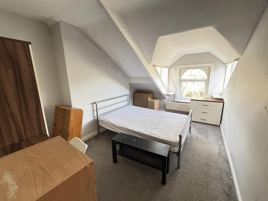 A bright, tidy bedroom with a large window allo...