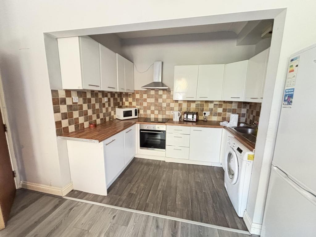 Bright, modern kitchen with white cabinets, int...