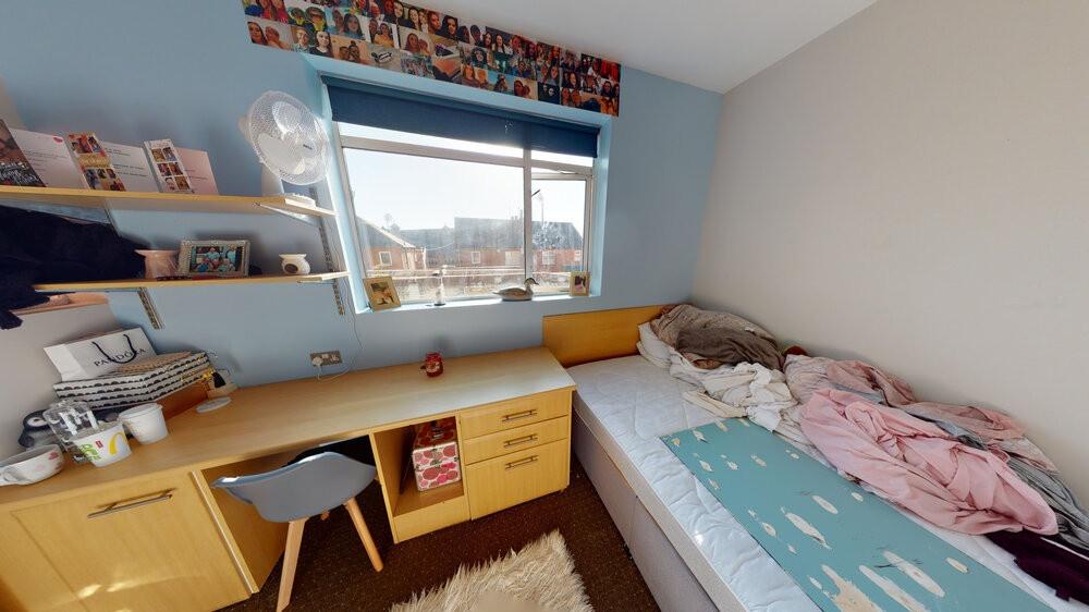 A cozy single bedroom with a comfortable bed, n...