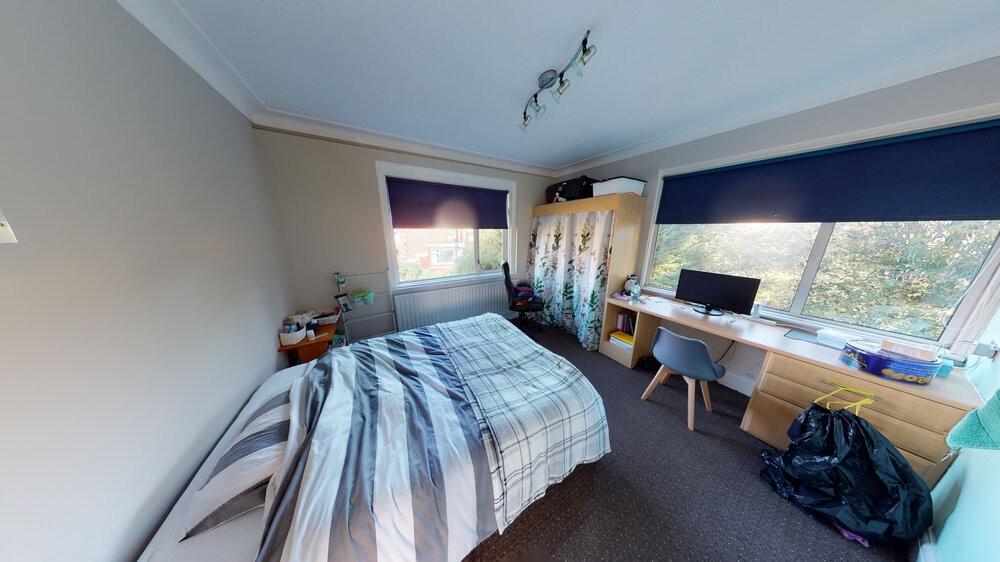 A cozy single bedroom featuring a comfortable b...