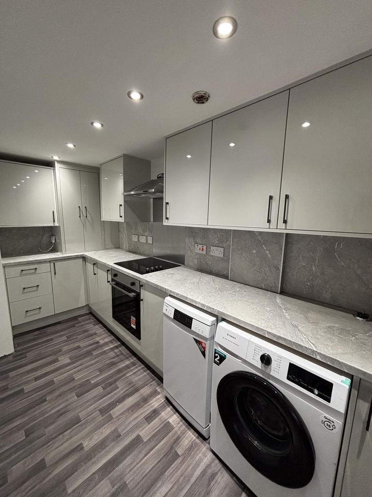 Modern, well-maintained kitchen with sleek whit...