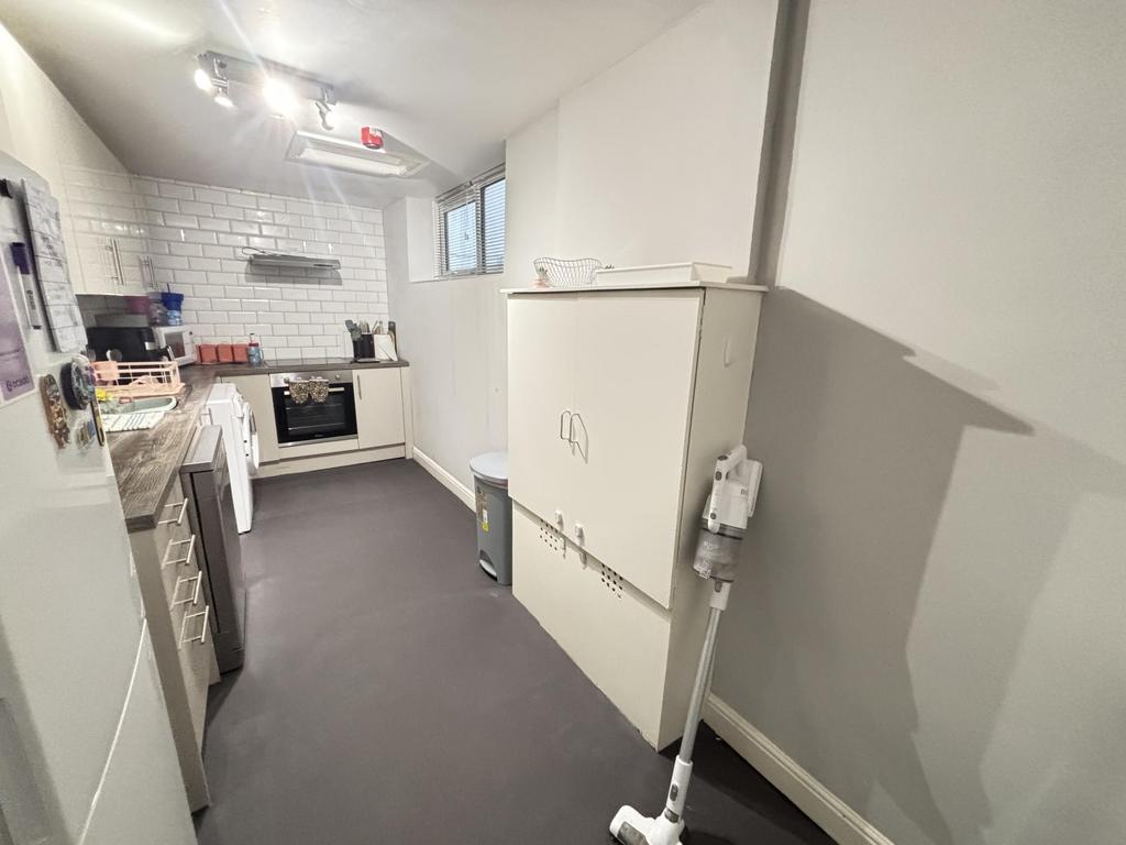 A compact but clean kitchen area with a window ...