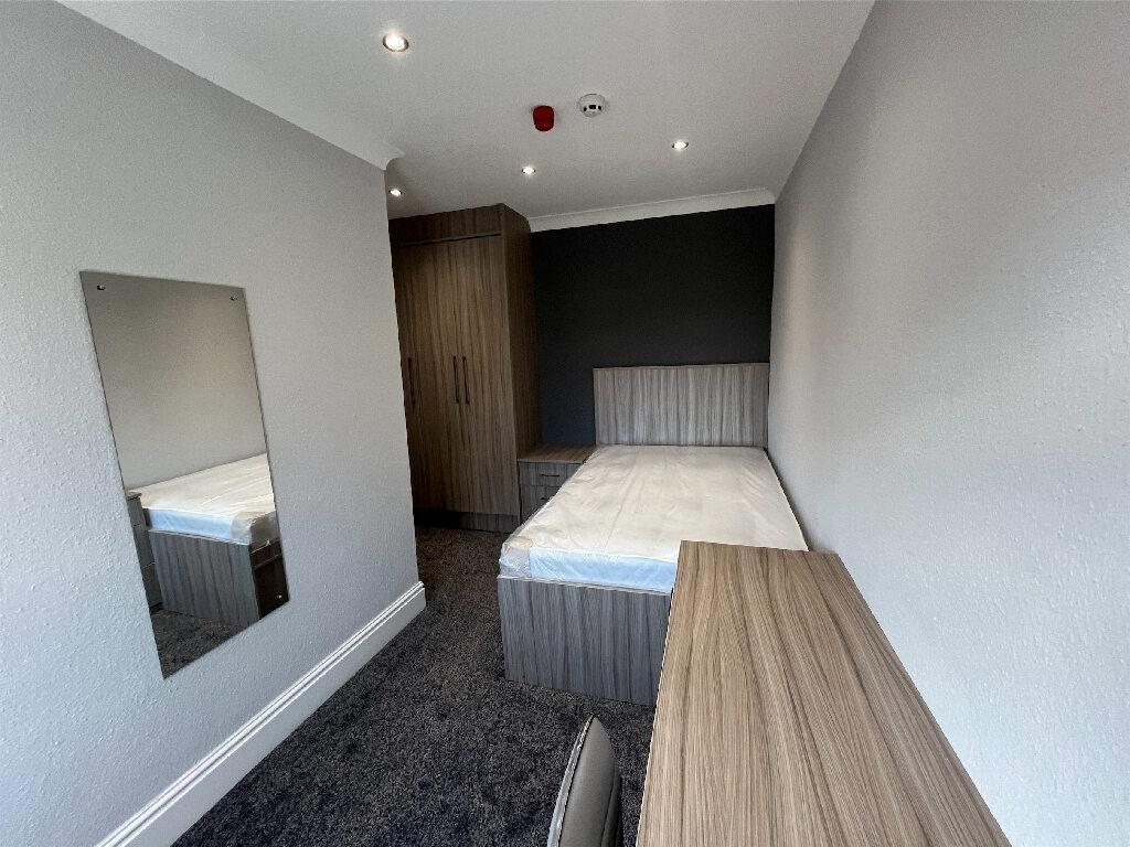 A neatly maintained single bedroom featuring a ...