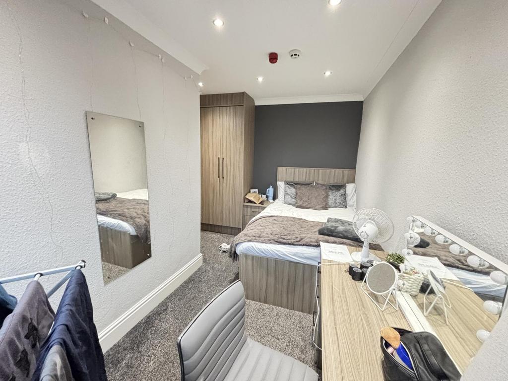 A well-maintained bedroom featuring a double be...