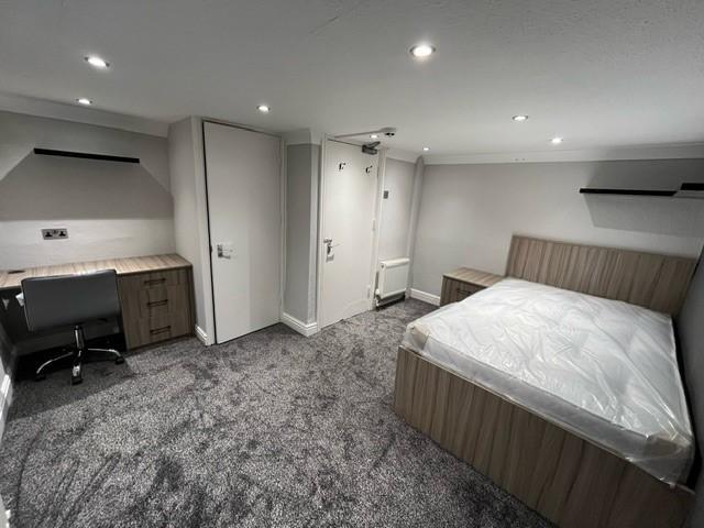 A clean, well-lit bedroom featuring a comfortab...
