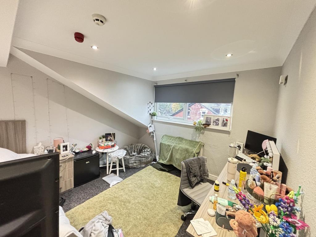 A spacious, well-lit living room with large win...