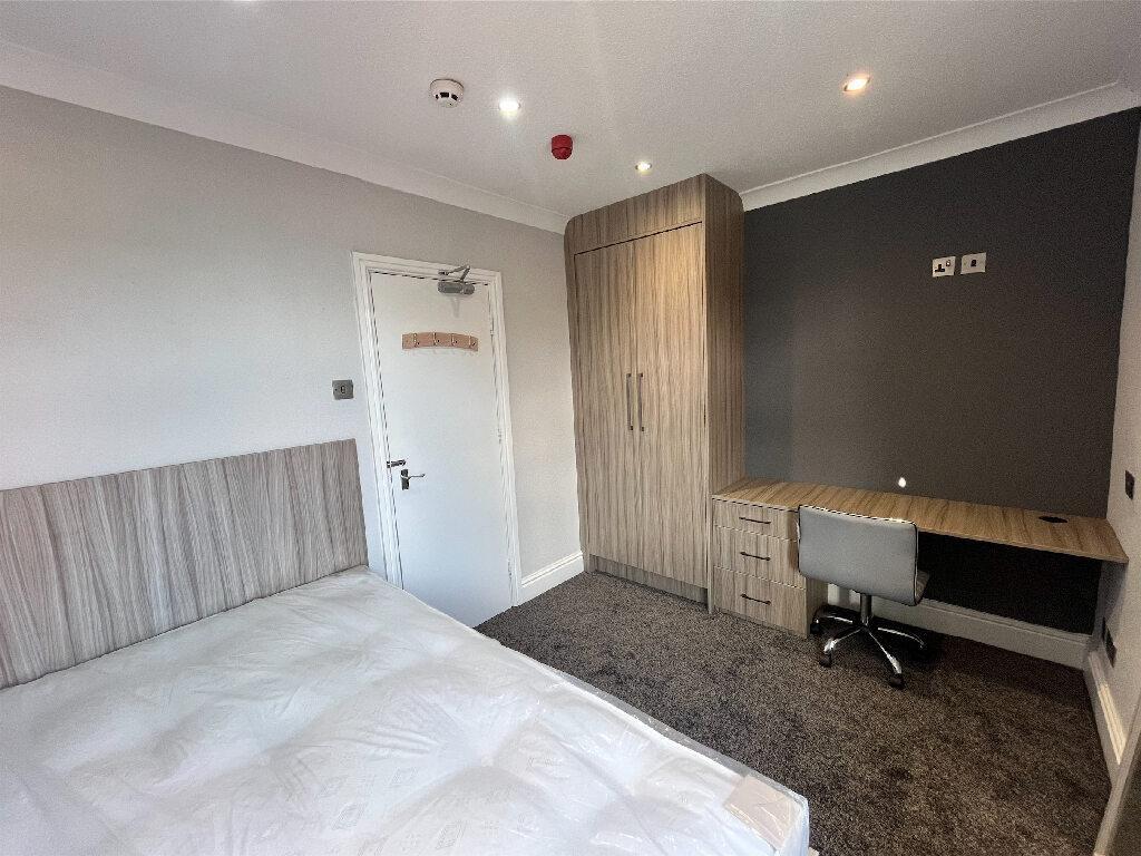 A neatly maintained bedroom featuring a bed, a ...