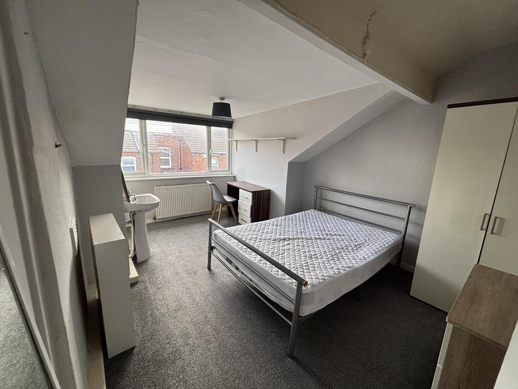 A bright and tidy bedroom featuring a comfortab...
