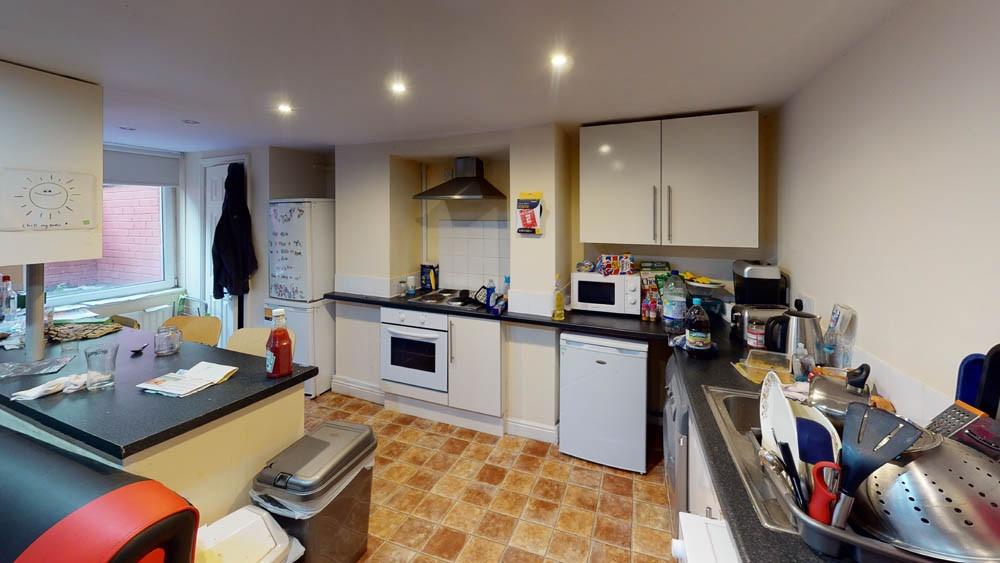 A well-equipped kitchen with white cabinets, a ...