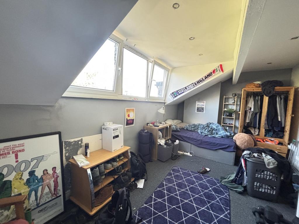 A cozy student bedroom with a large window prov...